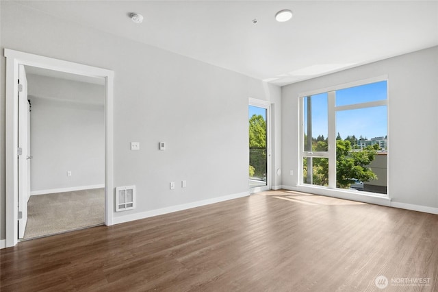 1085 103rd Ave NE Unit 217, Bellevue, WA 98004 - unfurnished room with a smoke detector, wood finished floors, and heating unit