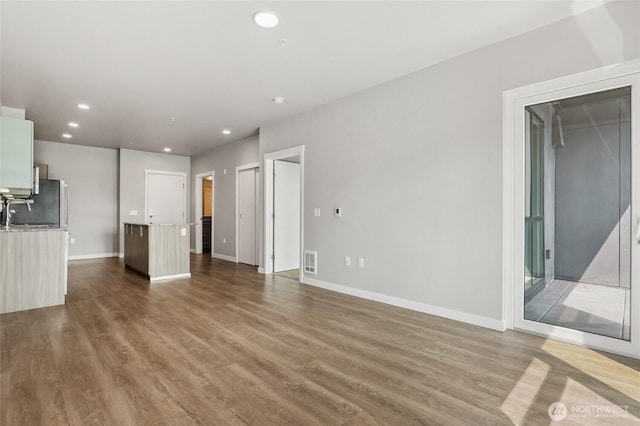 1085 103rd Ave NE Unit 217, Bellevue, WA 98004 - unfurnished living room featuring wood finished floors and recessed lighting