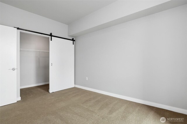 1085 103rd Ave NE Unit 217, Bellevue, WA 98004 - unfurnished bedroom with carpet floors, a barn door, and a closet