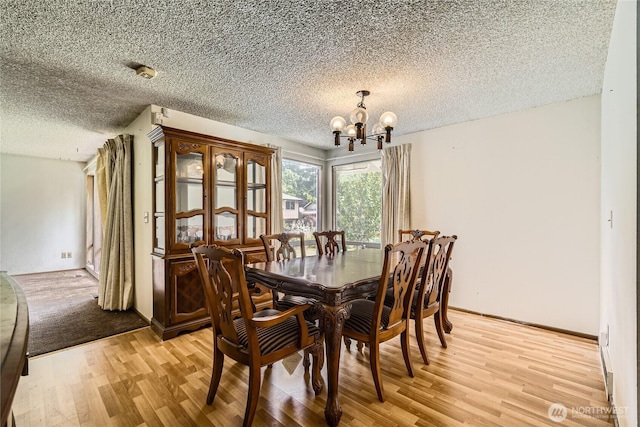 2708 NE 106th Pl, Seattle, WA 98125 - dining room featuring a chandelier, light wood-type flooring, and a textured ceiling
