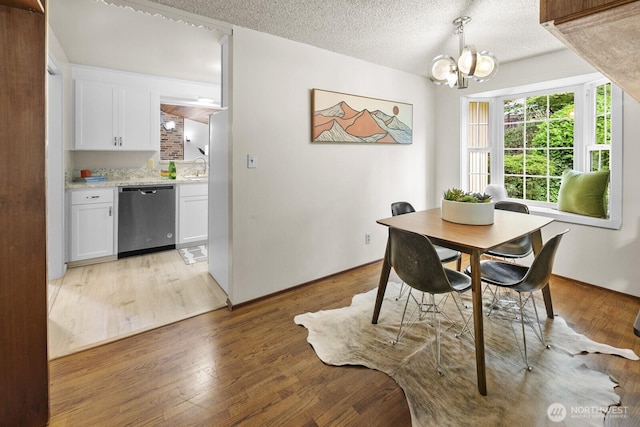 852 NE 194th St, Shoreline, WA 98155 - dining space featuring a chandelier, light wood-type flooring, and a textured ceiling