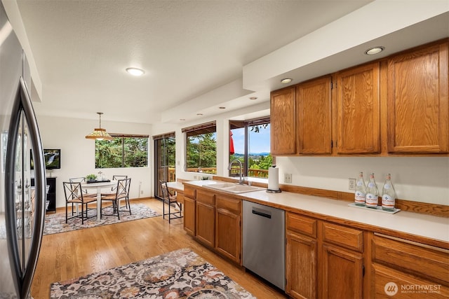 19212 94th Ave W, Edmonds, WA 98020 - kitchen with stainless steel appliances, brown cabinetry, recessed lighting, light wood-style floors, and healthy amount of natural light