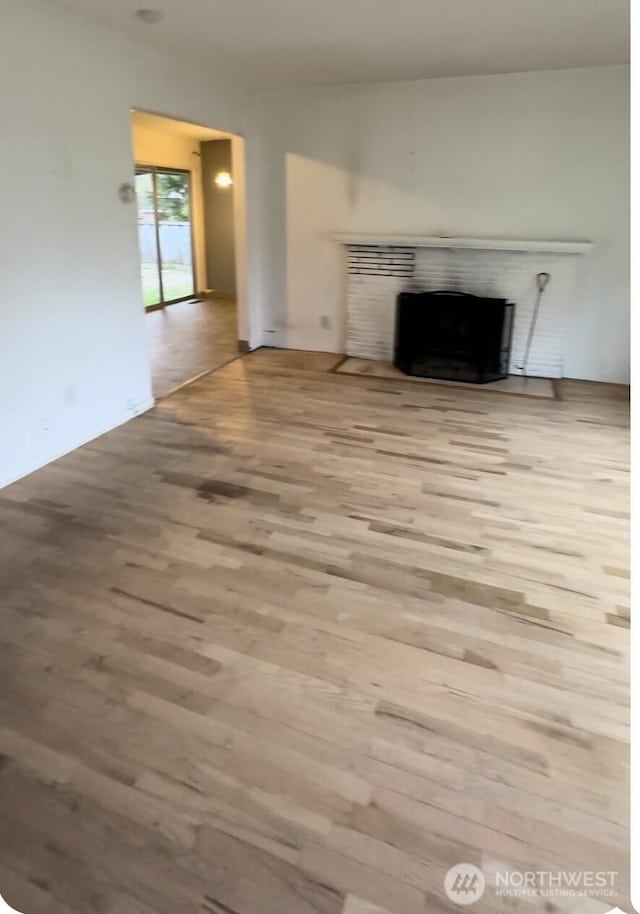 7702 202nd Pl SW, Edmonds, WA 98026 - unfurnished living room with wood finished floors and a fireplace