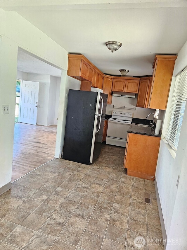 7702 202nd Pl SW, Edmonds, WA 98026 - kitchen featuring white range with electric stovetop, freestanding refrigerator, under cabinet range hood, and healthy amount of natural light