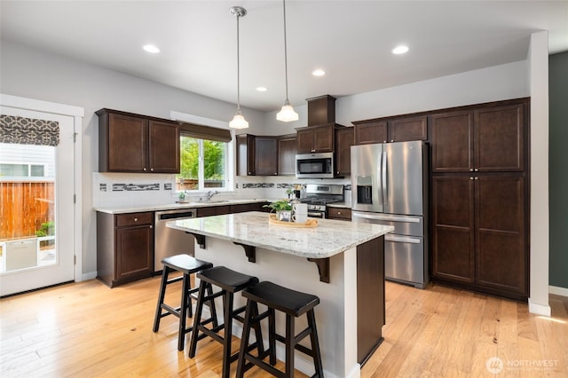 3885 Summersun St, Mount Vernon, WA 98273 - kitchen featuring stainless steel appliances, dark brown cabinets, light wood-type flooring, a kitchen breakfast bar, and recessed lighting