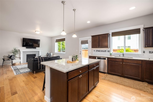3885 Summersun St, Mount Vernon, WA 98273 - kitchen featuring dishwasher, light wood-type flooring, a center island, decorative light fixtures, and tasteful backsplash