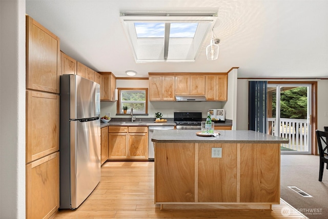 889 NE Sleepy Way, Bremerton, WA 98311 - kitchen with appliances with stainless steel finishes, a skylight, a kitchen island, light wood finished floors, and plenty of natural light