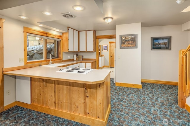 197 Swiftwater Ln, Leavenworth, WA 98826 - kitchen with white cooktop, a peninsula, light countertops, dark floors, and white cabinets