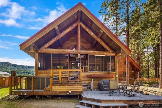 197 Swiftwater Ln, Leavenworth, WA 98826 - rear view of house with a sunroom, a deck, outdoor dining space, and a wooded view