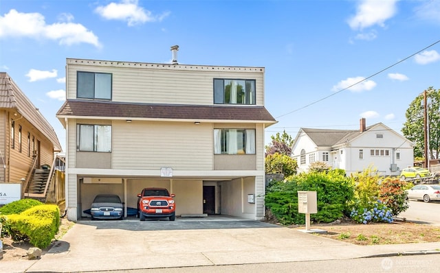 1612 33rd St Unit 102, Everett, WA 98201 - view of property with concrete driveway, a shingled roof, and stairway