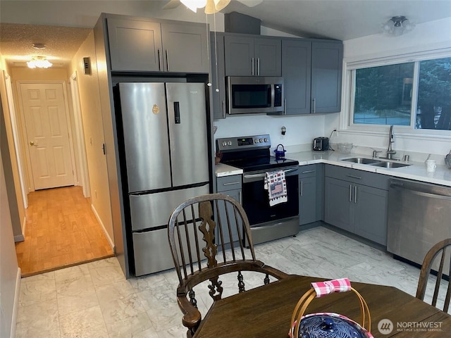 12611 50th Dr SE, Everett, WA 98208 - kitchen with stainless steel appliances, light marble finish floors, light countertops, lofted ceiling, and gray cabinets