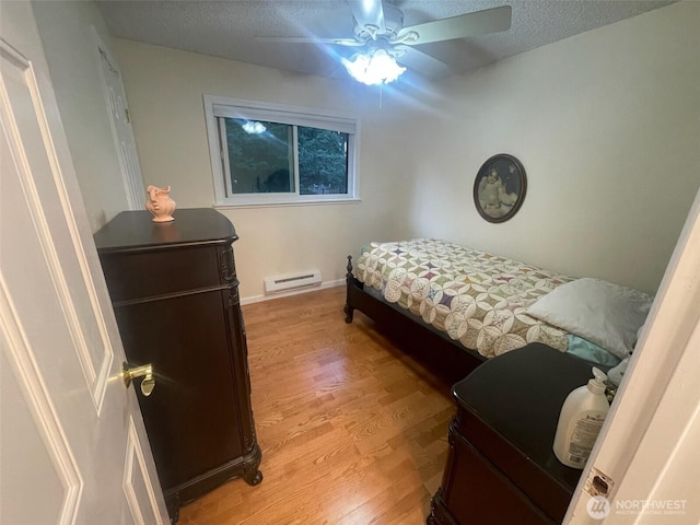 12611 50th Dr SE, Everett, WA 98208 - bedroom with a baseboard radiator, light wood-type flooring, a textured ceiling, and ceiling fan