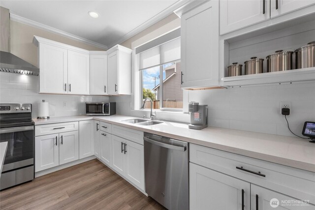 225 N Mcneely St, Buckley, WA 98321 - kitchen with stainless steel appliances, wall chimney exhaust hood, ornamental molding, decorative backsplash, and white cabinets