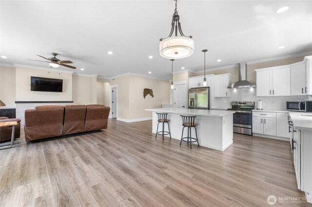 225 N Mcneely St, Buckley, WA 98321 - kitchen with appliances with stainless steel finishes, wall chimney exhaust hood, open floor plan, recessed lighting, and a center island
