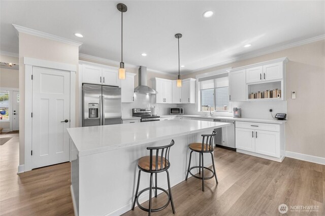 225 N Mcneely St, Buckley, WA 98321 - kitchen featuring stainless steel appliances, crown molding, wall chimney exhaust hood, a kitchen island, and white cabinetry