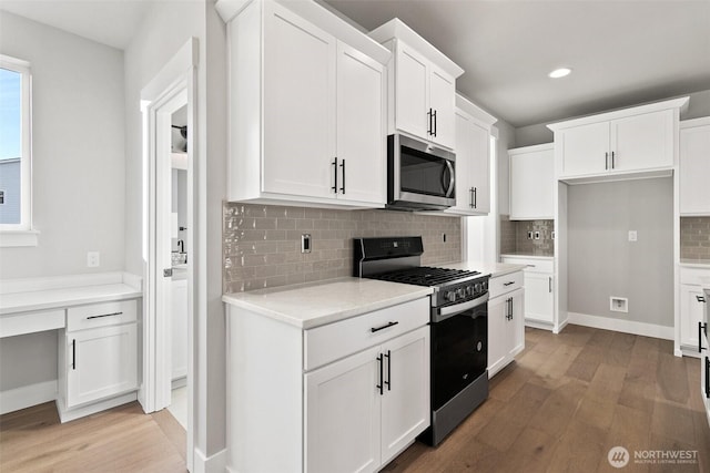 15705LOT13 SE 257th St, Covington, WA 98042 - kitchen with stainless steel appliances, light wood finished floors, tasteful backsplash, white cabinetry, and recessed lighting
