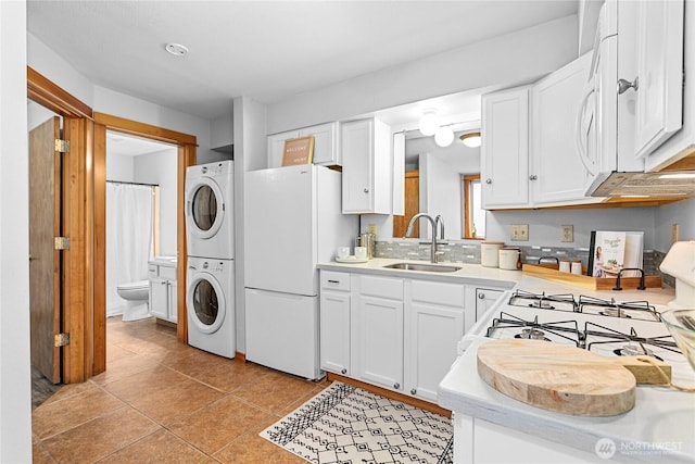 1007 N Forest St, Bellingham, WA 98225 - kitchen with estacked washer and dryer, white appliances, light countertops, and white cabinetry