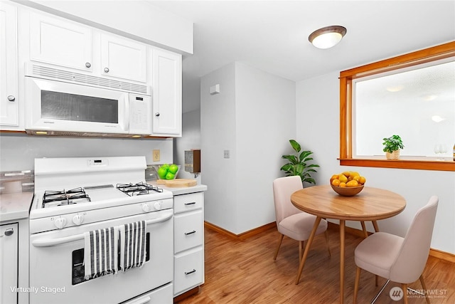 1007 N Forest St, Bellingham, WA 98225 - kitchen with white appliances, light countertops, light wood finished floors, and white cabinetry
