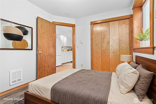 1007 N Forest St, Bellingham, WA 98225 - bedroom with freestanding refrigerator, a closet, and wood finished floors
