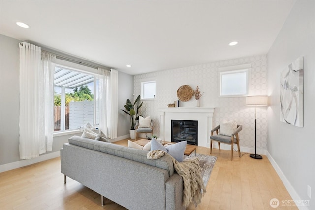 20402 1st Pl W, Lynnwood, WA 98036 - living room featuring wallpapered walls, a glass covered fireplace, light wood-style floors, an accent wall, and recessed lighting