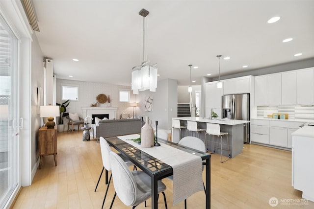 20402 1st Pl W, Lynnwood, WA 98036 - dining space with light wood-type flooring, stairs, recessed lighting, and a fireplace