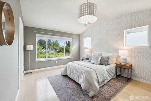 20402 1st Pl W, Lynnwood, WA 98036 - bedroom with wallpapered walls, an accent wall, wood finished floors, and a chandelier