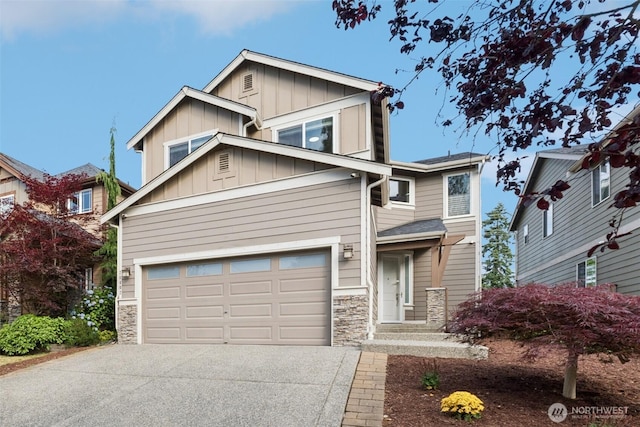 20402 1st Pl W, Lynnwood, WA 98036 - view of front of house with driveway, stone siding, a garage, and board and batten siding