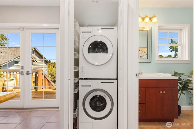 1628 27th Ave, Seattle, WA 98122 - washroom featuring estacked washer and dryer, light tile patterned flooring, and healthy amount of natural light