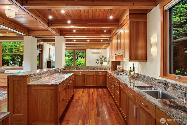 7715 NE 22nd St, Medina, WA 98039 - kitchen featuring a wood ceiling with exposed beams, light wood-style floors, brown cabinets, light stone countertops, and stainless steel gas cooktop