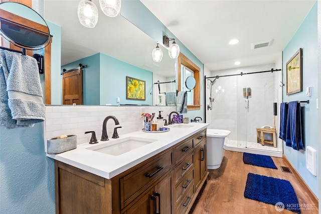 9317 214th Ave E, Bonney Lake, WA 98391 - full bath featuring a stall shower, wood finished floors, double vanity, decorative backsplash, and recessed lighting