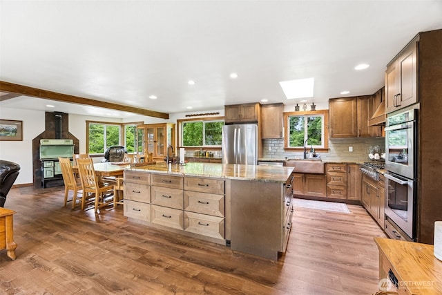 9317 214th Ave E, Bonney Lake, WA 98391 - kitchen featuring appliances with stainless steel finishes, wood finished floors, healthy amount of natural light, a kitchen island with sink, and recessed lighting