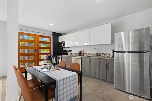 4603 S Juneau St, Seattle, WA 98118 - kitchen with stainless steel appliances, white cabinetry, recessed lighting, modern cabinets, and light carpet