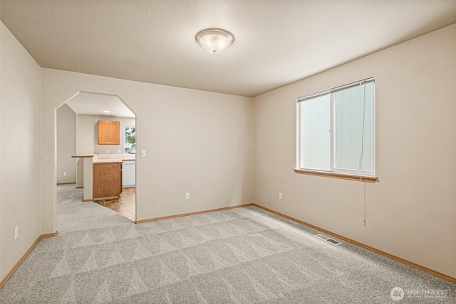 3724 30th Ave SE, Olympia, WA 98501 - spare room featuring light colored carpet and arched walkways