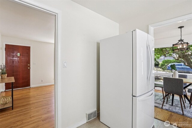 8902 17th Ave NE, Seattle, WA 98115 - kitchen featuring freestanding refrigerator, light wood-type flooring, and a chandelier