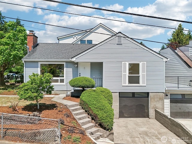 8902 17th Ave NE, Seattle, WA 98115 - view of front of house featuring a garage, concrete driveway, a shingled roof, and a chimney