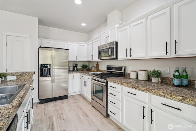 1341 52nd St NE Unit 1205, Auburn, WA 98002 - kitchen with appliances with stainless steel finishes, white cabinets, light wood-type flooring, dark stone countertops, and recessed lighting