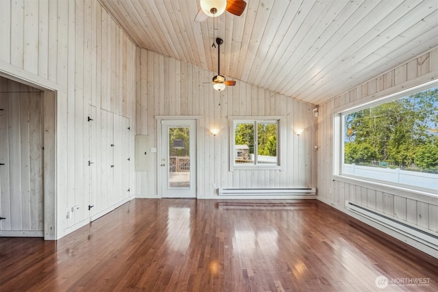 13540 E State Route 106, Belfair, WA 98528 - unfurnished living room with a ceiling fan, a baseboard radiator, wood walls, wood finished floors, and vaulted ceiling