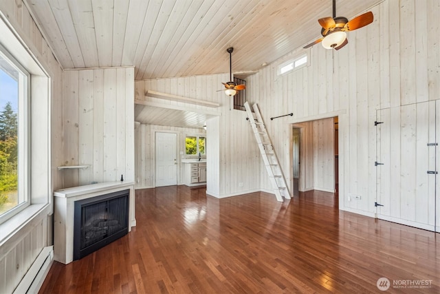 13540 E State Route 106, Belfair, WA 98528 - unfurnished living room featuring a baseboard radiator, ceiling fan, wood walls, wood finished floors, and high vaulted ceiling