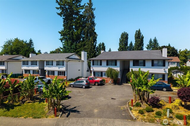 3834 D Pl SE, Auburn, WA 98002 - view of front facade featuring a chimney, uncovered parking, stairs, and a residential view