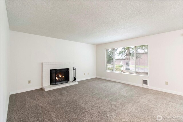 3834 D Pl SE, Auburn, WA 98002 - unfurnished living room featuring carpet floors, a textured ceiling, and a brick fireplace