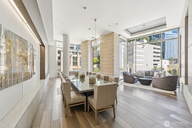 10610 NE 9th Pl Unit C4210, Bellevue, WA 98004 - dining area featuring healthy amount of natural light, wood finished floors, a city view, and a tray ceiling