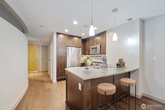 10610 NE 9th Pl Unit C4210, Bellevue, WA 98004 - kitchen with appliances with stainless steel finishes, light wood-style flooring, a breakfast bar area, a peninsula, and recessed lighting
