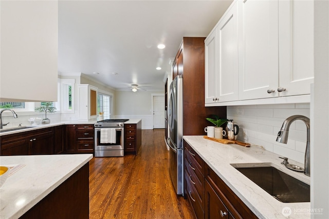 2515 16th St, Anacortes, WA 98221 - kitchen with appliances with stainless steel finishes, white cabinetry, light stone counters, dark wood-style flooring, and recessed lighting