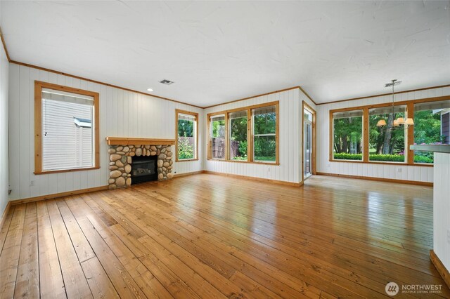 847 SE Covey Ct, College Place, WA 99324 - unfurnished living room with ornamental molding, hardwood / wood-style floors, a fireplace, and wooden walls