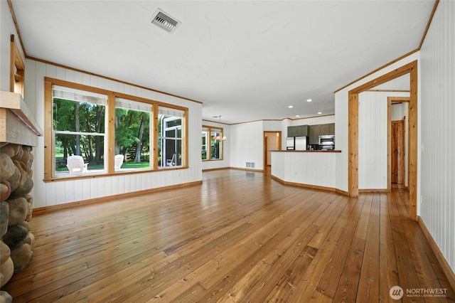 847 SE Covey Ct, College Place, WA 99324 - unfurnished living room featuring hardwood / wood-style floors, a fireplace, crown molding, and wood walls