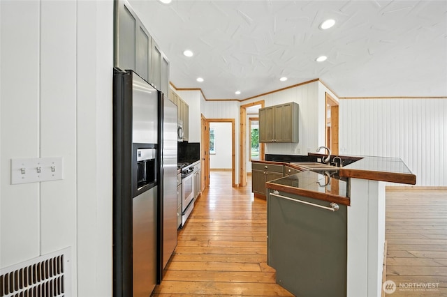 847 SE Covey Ct, College Place, WA 99324 - kitchen with stainless steel appliances, dark countertops, crown molding, light wood-style flooring, and a peninsula