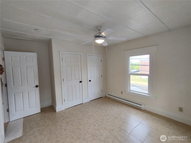 316 N F, Aberdeen, WA 98520 - unfurnished bedroom featuring a baseboard heating unit, light tile patterned floors, multiple closets, and a ceiling fan