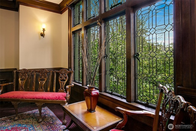 living area featuring crown molding and healthy amount of natural light