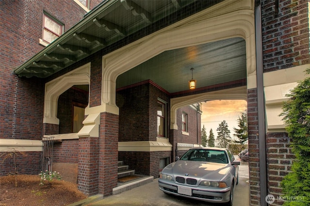exterior entry at dusk featuring brick siding
