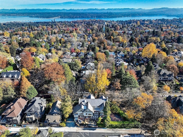 aerial overview of property's location with a water and mountain view and nearby suburban area